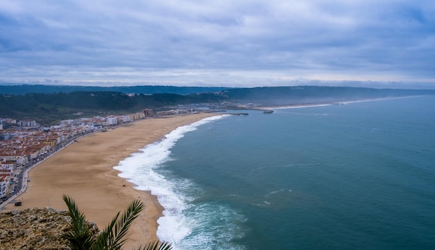 Awesome aerial sunny seascape coastline of Atlantic ocean View North Beach Praia do Norte Most famous place of giant breaking waves for surfers from around the world Nazare Portugal