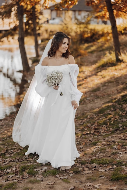 Awesome bride in a long wedding dress with a beautiful bouquet in hand