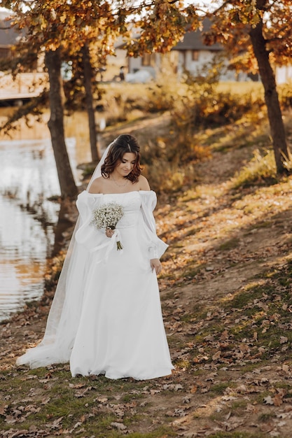 Awesome bride in a long wedding dress with a beautiful bouquet i