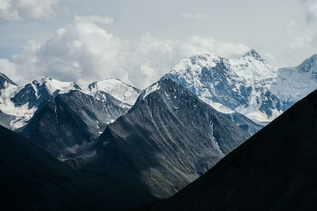 Awesome landscape with huge glacial mountains in bad cloudy weather Low stormy clouds