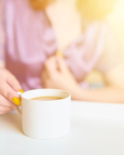 Awesome mooie vrouw in een paarse zijden mantel drinken koffie vroeg in de ochtend in bed.