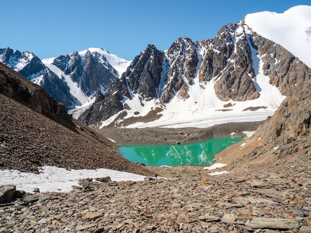 Awesome mountain glacial massif with a lake summer mountain\
camp on the shore of a cold turquoise glacial lake distant view\
mountaineering camp at the blue lake aktru mountain range\
altai