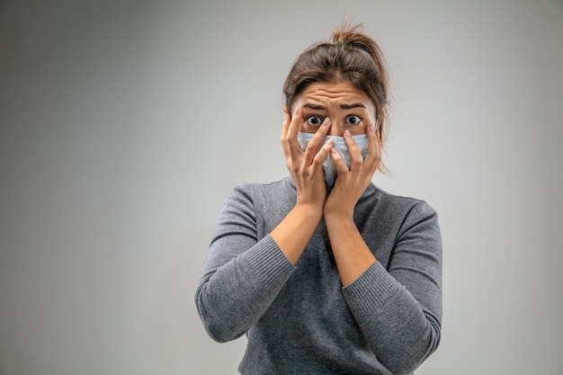Ужасная жизнь. Кавказская женщина в респираторной маске от загрязнения воздуха и частиц пыли превышает пределы безопасности. Концепция здравоохранения, окружающей среды, экологии. Аллергия, головная боль.