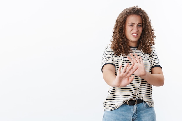 Awful take away from face Disgusted displeased intense disliking young chubby girl restraining raise hand stop enought refusal gesture cringing aversion show reluctance declining product