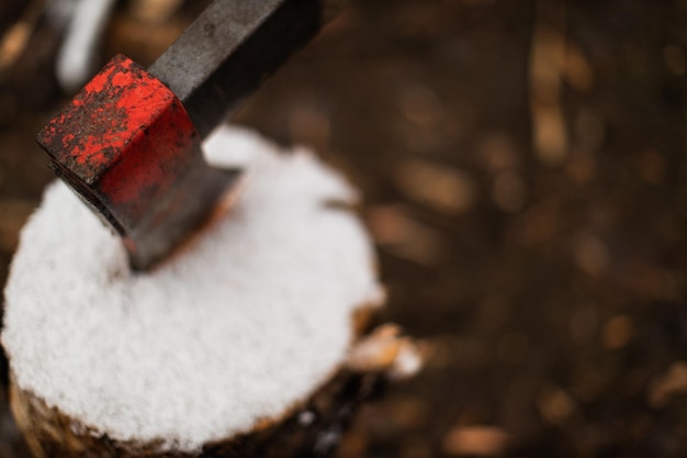 Foto ascia nel blocco di legno in inverno