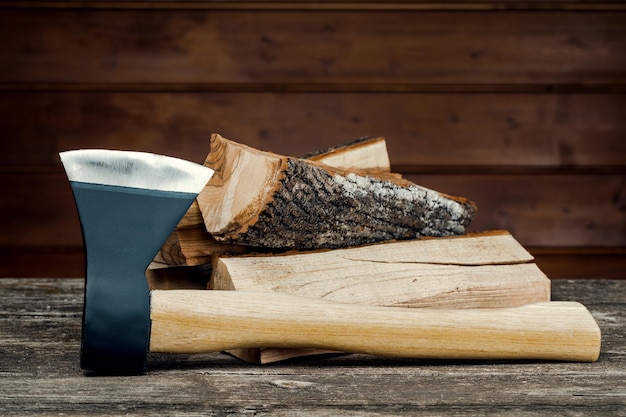 Axe and firewood, against the background of wooden boards.