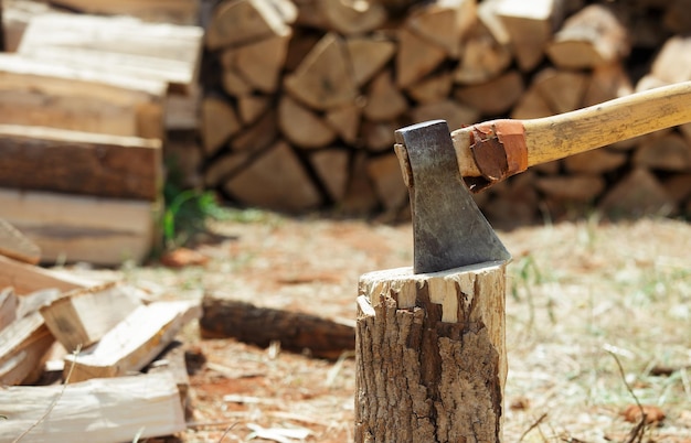 刻んだ薪の丸太の山の近くの切り株の斧。木材の分割。閉じる。
