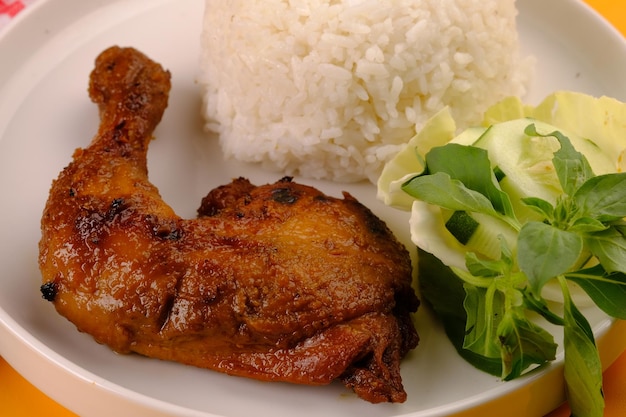 аям бакар. курица-гриль, рис, нарезанная капуста, огурец, базилик и соус чили. индонезийская кухня