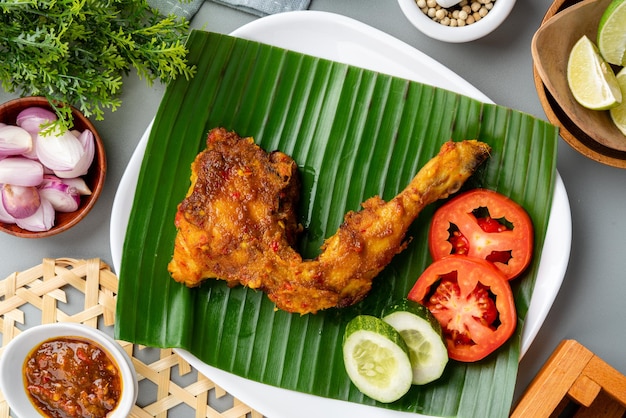 Ayam bakar or roasted chicken on banana leaf Ayam bakar is a indonesian dish