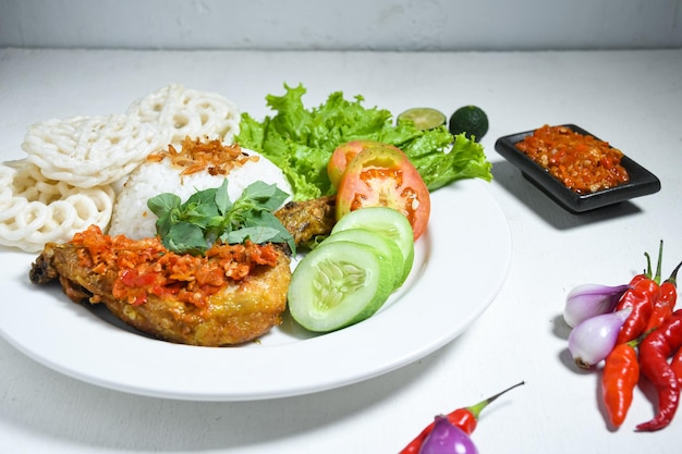 Ayam geprek indonesisch eten of geprek kip met sambal hete chilisaus geserveerd rijst op witte plaat