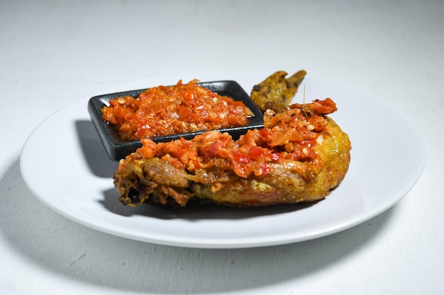 Ayam geprek sambal 인도네시아 음식 또는 geprek 프라이드 치킨과 삼발 핫 칠리 소스.