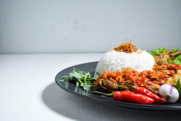Ayam geprek sambal 인도네시아 음식 또는 geprek 프라이드 치킨과 삼발 핫 칠리 소스.