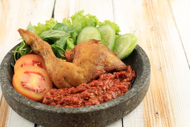 매콤한 삼발과 함께 제공되는 Ayam Penyet 또는 Penyetan Ayam 프라이드 치킨