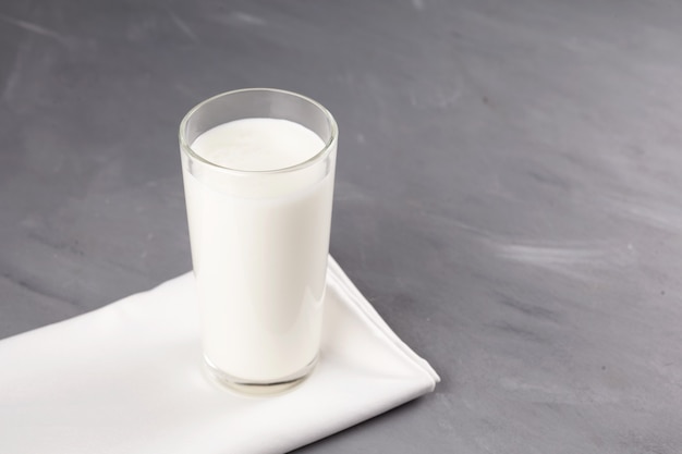 Ayran of kefir in een glas op een grijze achtergrond. Gefermenteerde melk ayran. Melkdieet om af te vallen.