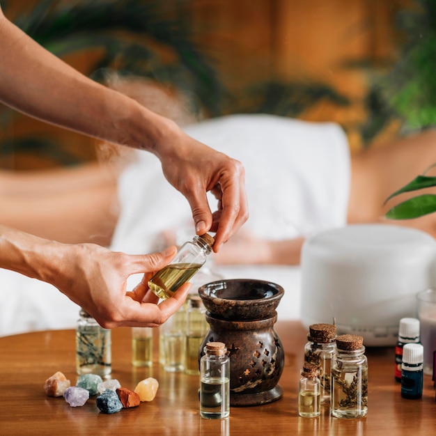 Foto ayurveda aromaterapia massaggio mano femminile versando olio aromatico in un diffusore di olio essenziale