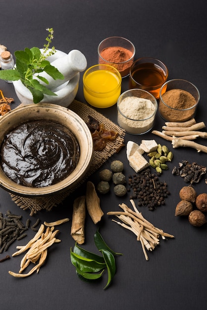 사진 ayurvedic chyawanprash는 강력한 면역 강화제 또는 자연 건강 보조제입니다. 변덕스러운 배경 위에 재료와 함께 골동품 그릇에 제공, 선택적 초점