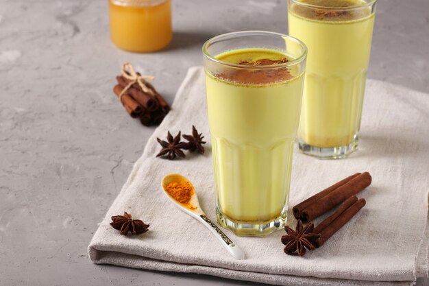 Latte ayurvedico dorato alla curcuma in vetro con curcuma, anice stellato di cannella