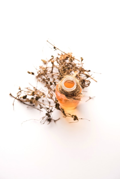 Ayurvedic Maha Bhringraj or Mahabhringraj Hair Oil with dried leaves and mortar,