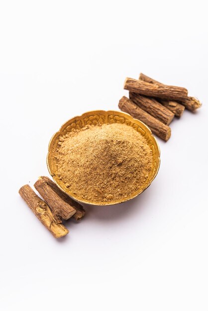 아유르베다 무레티 (Ayurvedic Mulethi) 또는 레코리스 뿌리 스틱 (Licorice root stick) 또는 제슈타마드 파우더 (jeshthamadh powder) 는 분위기적인 배경 위에 그으로 제공됩니다.