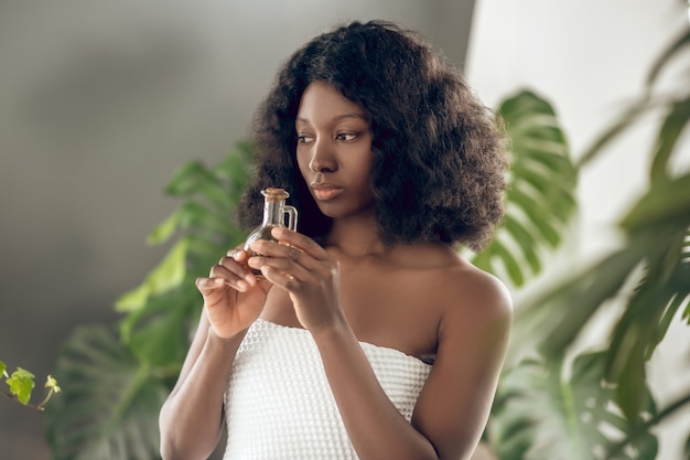 Ayurvedic salon. Cute dark-skinned young womna with essential oils in hand