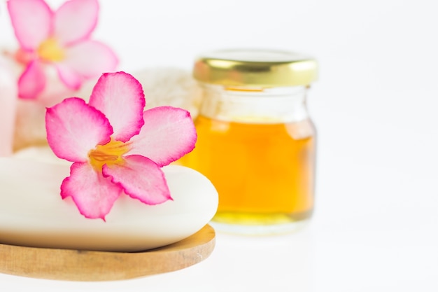 Azalea flowers on piece soap and blur liquid soap background, wooden ladle on white background,