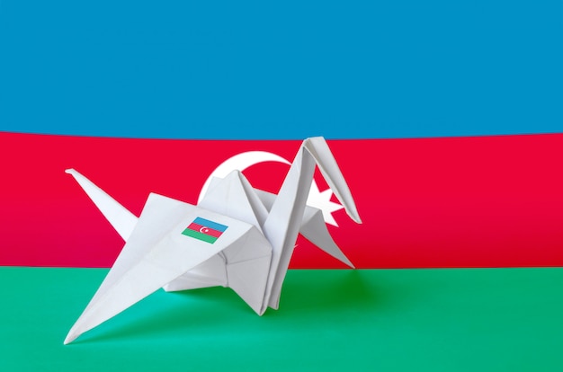 Azerbaijan flag depicted on paper origami crane wing. Handmade arts concept