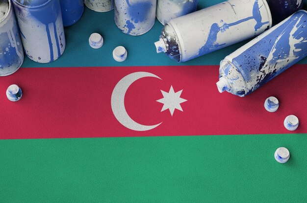 Azerbaijan flag and few used aerosol spray cans for graffiti\
painting street art culture concept