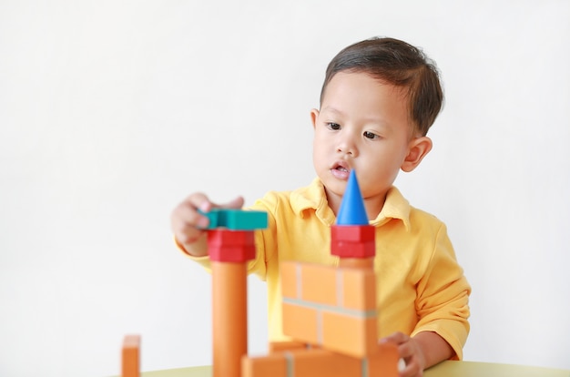 Aziaat weinig jongen die met houten speelgoed speelt