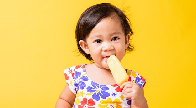 Aziatisch babymeisje aantrekkelijk eten van ijs