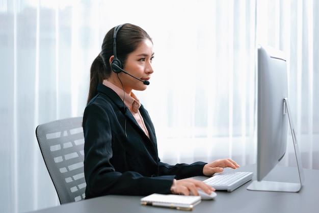 Aziatisch callcenter met headset en microfoon aan het werk op haar laptop Vrouwelijke operator biedt uitzonderlijke klantenservice Ondersteunende callcenteragent helpt klant op aanvraag Enthousiast