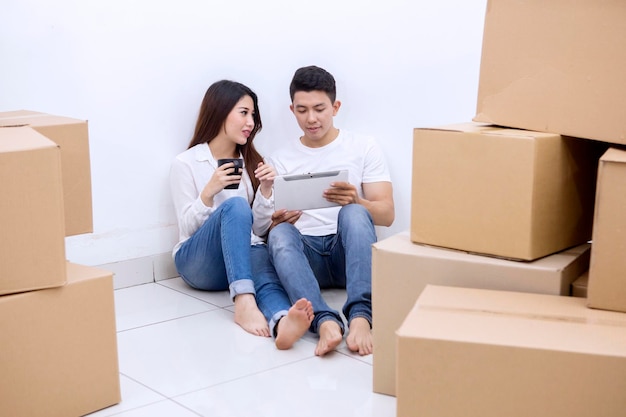 Aziatisch echtpaar rust tijdens het verhuizen naar een nieuw huis