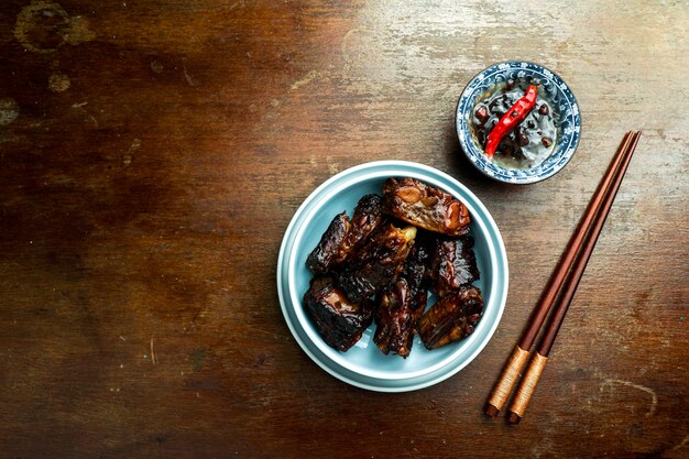 Aziatisch eten, gekarameliseerde varkensribbetjes, donkere houten achtergrond, Chinees eten