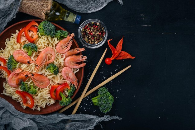 Aziatisch eten met zeevruchten en groenten. Garnalen, broccoli, paprika, kruiden. Bovenaanzicht. Vrije ruimte voor tekst.