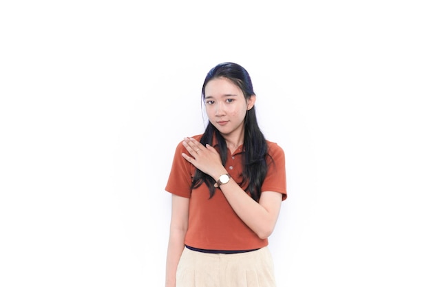 Aziatisch Indonesisch model dat glimlacht met één arm gekruist en een oranje shirt draagt