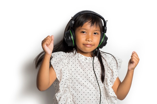 Aziatisch klein kindmeisje dat van muziek geniet. dansen en bewegen die echte positieve emoties uitdrukken