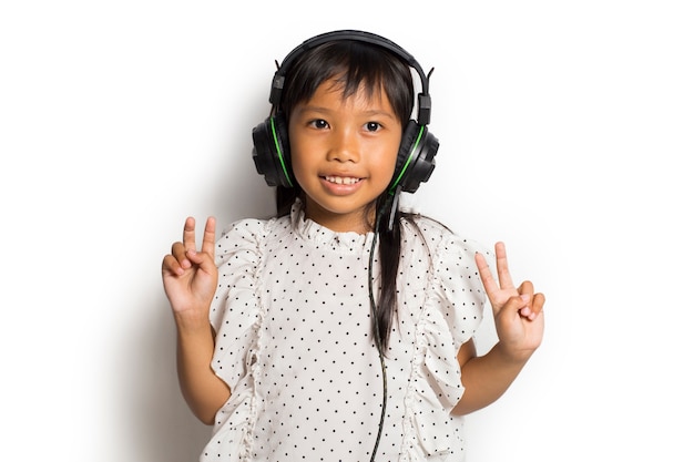 Aziatisch klein kindmeisje dat van muziek geniet. dansen en bewegen die echte positieve emoties uitdrukken