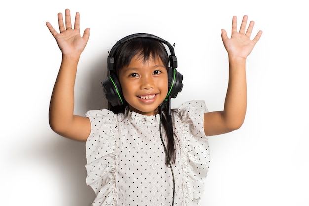 Aziatisch klein kindmeisje dat van muziek geniet. dansen en bewegen die echte positieve emoties uitdrukken