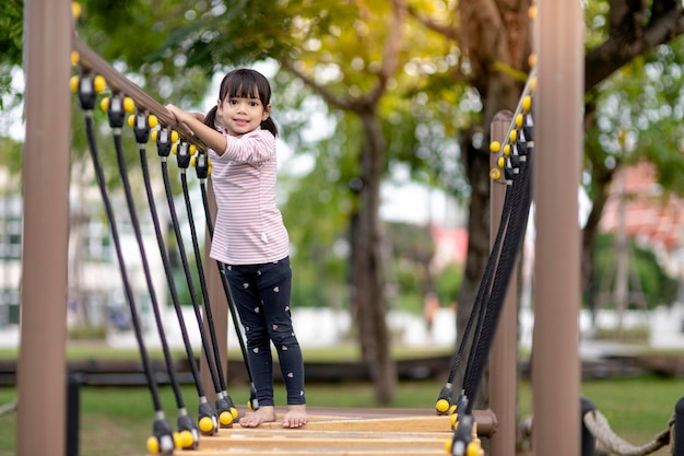 Aziatisch klein meisje speelt graag in een kinderspeelplaats Outdoor portrait