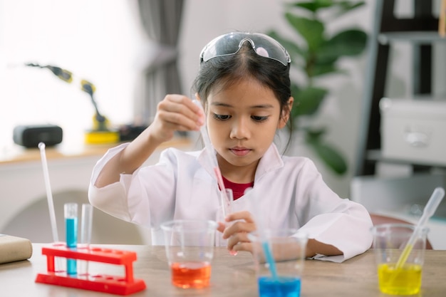 Foto aziatisch meisje doet chemische experimenten in het lab.