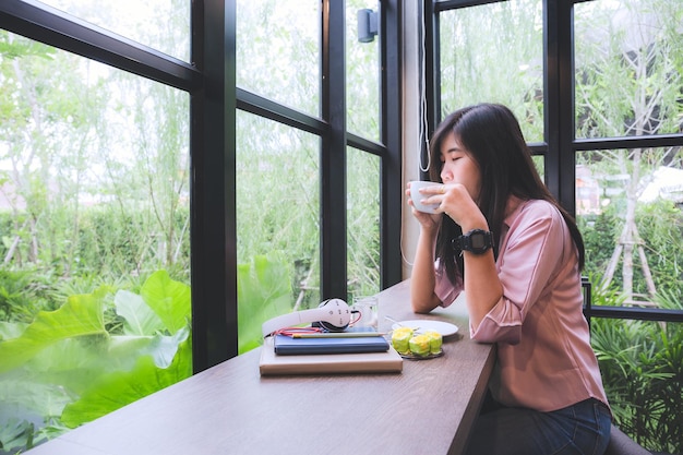 Aziatisch meisje in een coffeeshopLifestyle Technology Concept Aziatische vrouw die app op een slimme telefoon gebruikt