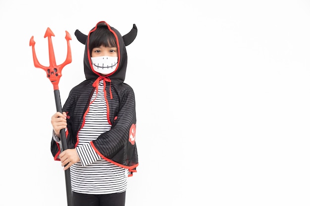 Aziatisch meisje in een Halloween-kostuum met een medisch masker. Halloween met veiligheidsmaatregelen van Covid-19