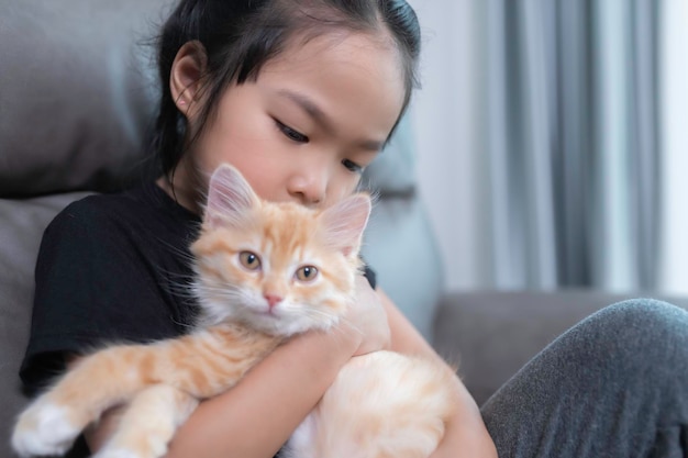 Aziatisch meisje met haar schattige kat, ze speelt met kitten