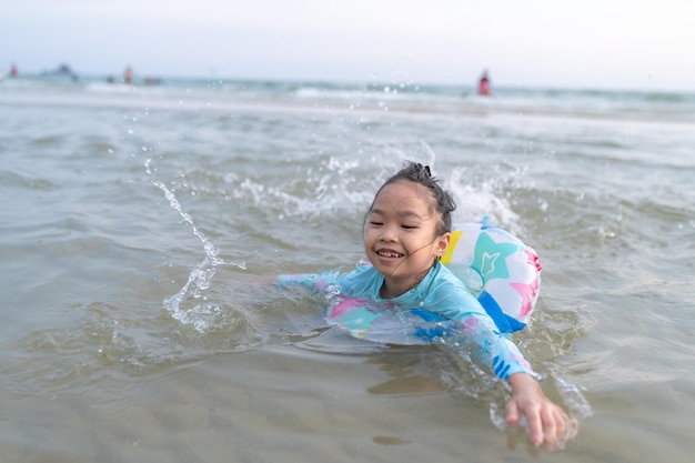 Aziatisch meisje speelt zee met plezierZomertijd met familieKindersemester pauze-activiteiten