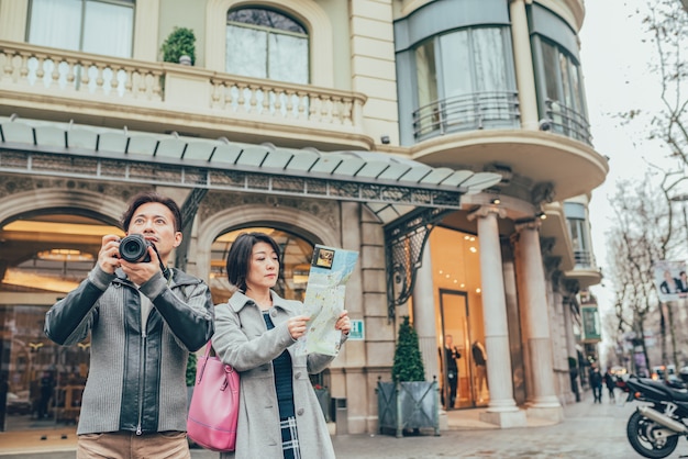 Aziatisch paar op vakantie met een stadskaart en een camera