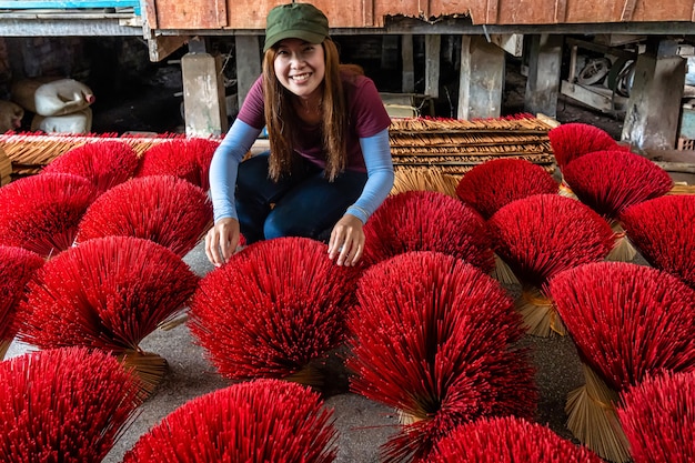 Aziatisch reizigerswijfje die de traditionele Vietnam rode insense in oud traditioneel huis maken bij lange xuyen, een provincie Giang, Vietnam