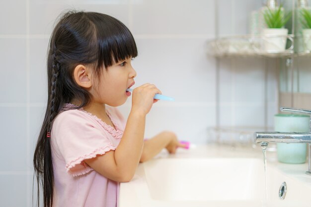 Aziatisch schattig kind meisje of kind Knijp de tandpasta in tandenborstel