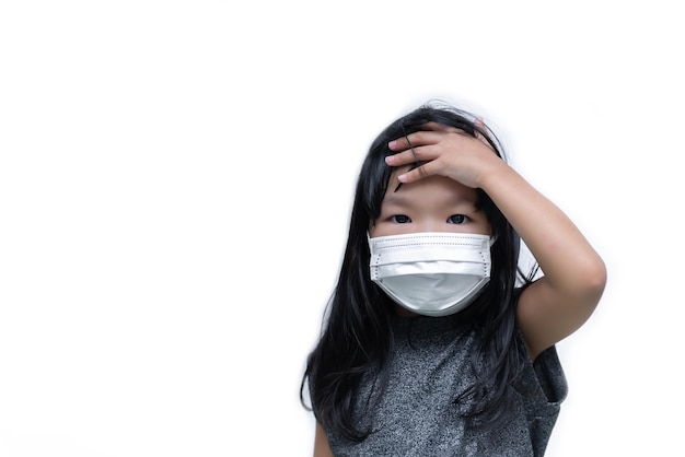 Aziatisch schattig klein meisje draagt een masker op een witte achtergrond Een meisje dat een medisch beschermingsmasker draagt covid19