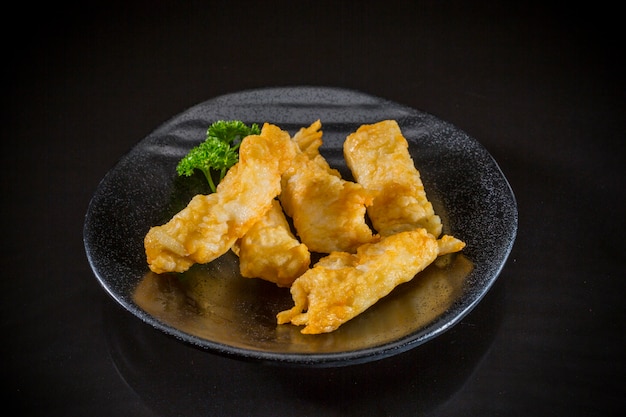 Aziatisch voedsel, gebraden vissentofu op zwarte achtergrond, Japans traditioneel voedsel