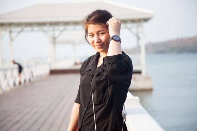 Aziatisch vrouwen zwart overhemd dat zich houten terras bevindt