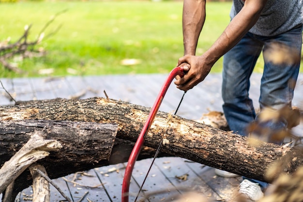 Aziatische arbeider zag log dode boom in kleine stukjes voor het volgende proces